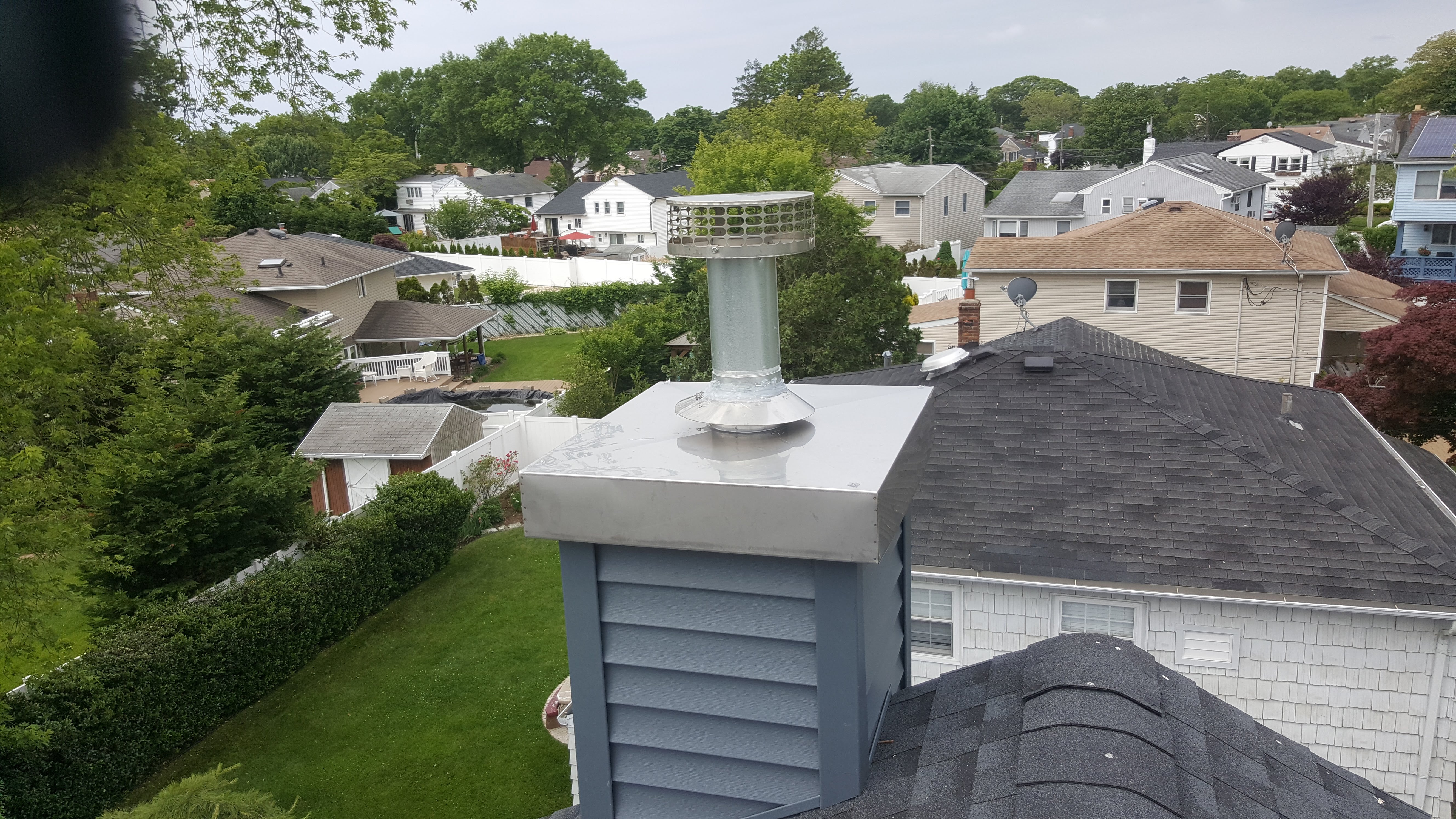 Technicians installing a chimney chase cover in Montauk